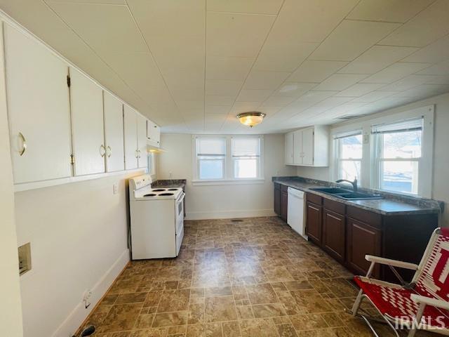 kitchen featuring white appliances, white cabinetry, sink, and dark brown cabinetry