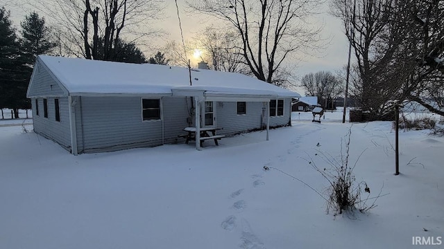 view of snow covered back of property