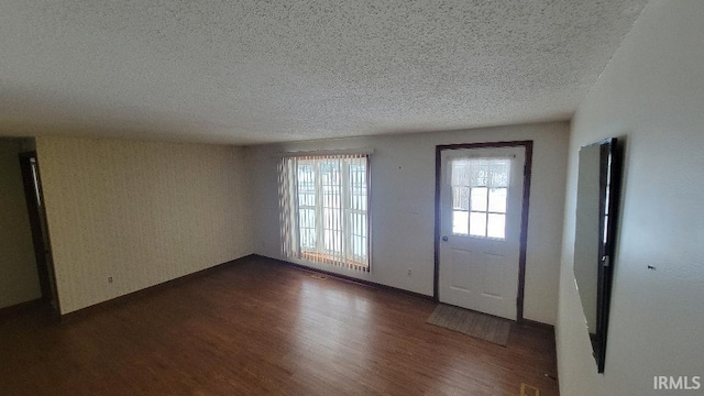 foyer entrance featuring a textured ceiling and dark hardwood / wood-style flooring