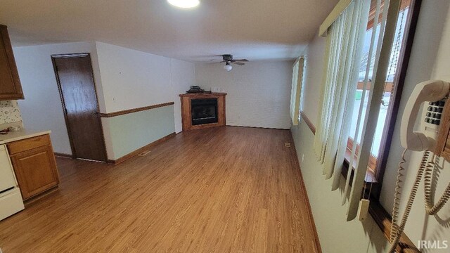 unfurnished living room with ceiling fan and light hardwood / wood-style floors