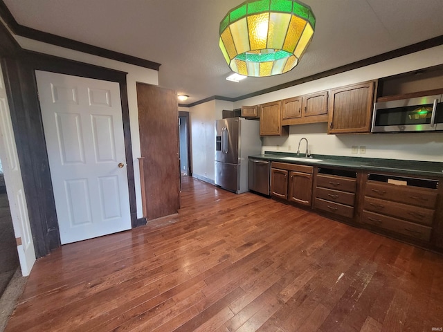 kitchen with sink, dark hardwood / wood-style flooring, crown molding, and appliances with stainless steel finishes