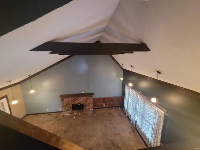 unfurnished living room with a brick fireplace, carpet floors, and lofted ceiling with beams