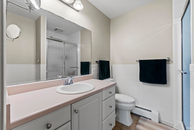 bathroom with tile walls, toilet, walk in shower, a baseboard radiator, and vanity