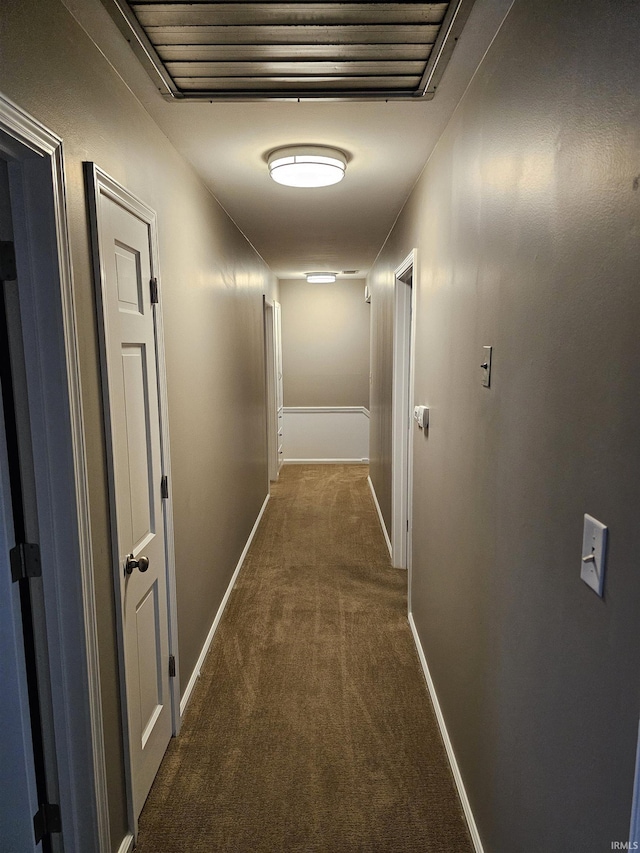 hallway featuring dark colored carpet