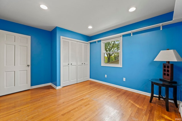 unfurnished bedroom featuring hardwood / wood-style floors and a closet