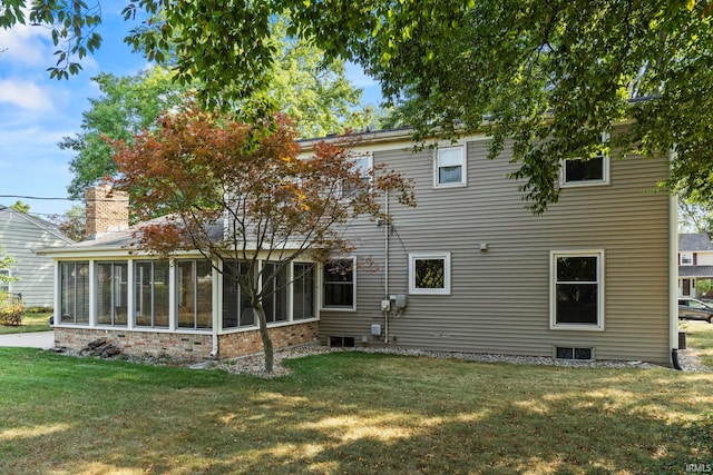 back of house featuring a yard and a sunroom