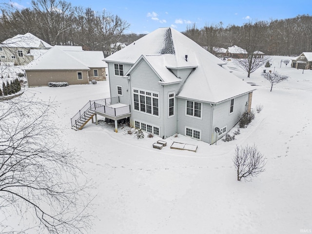 snow covered house with a deck