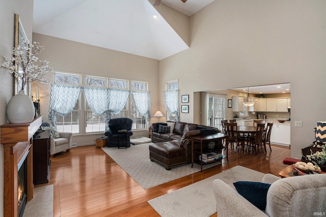 living room with a towering ceiling and light hardwood / wood-style flooring