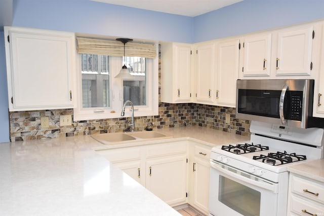 kitchen with sink, decorative light fixtures, white range with gas stovetop, and white cabinetry