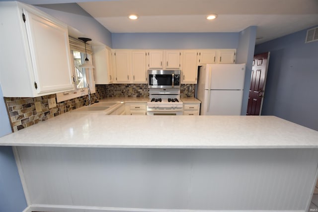 kitchen with white appliances, kitchen peninsula, backsplash, white cabinetry, and sink