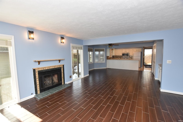 unfurnished living room with ceiling fan and a textured ceiling