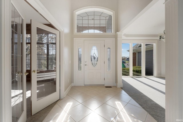 carpeted entrance foyer with french doors and a towering ceiling