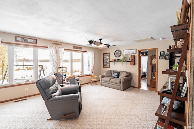 carpeted living room featuring a textured ceiling and ceiling fan