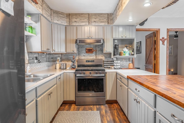 kitchen with sink, tasteful backsplash, stainless steel gas range oven, wooden counters, and dark hardwood / wood-style floors