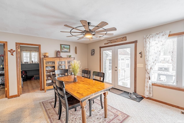 carpeted dining space with ceiling fan, french doors, and a wealth of natural light