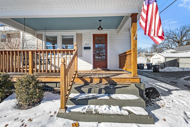 snow covered property entrance featuring a porch