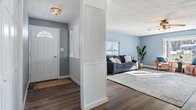 entrance foyer featuring dark wood-type flooring, a textured ceiling, and ceiling fan