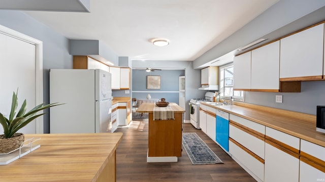 kitchen with a kitchen island, white appliances, and white cabinets