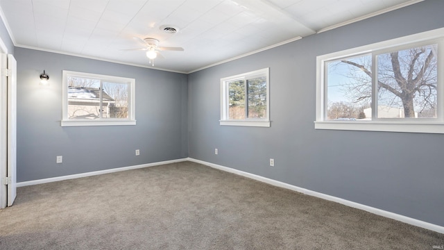 carpeted empty room with a healthy amount of sunlight, ceiling fan, and ornamental molding