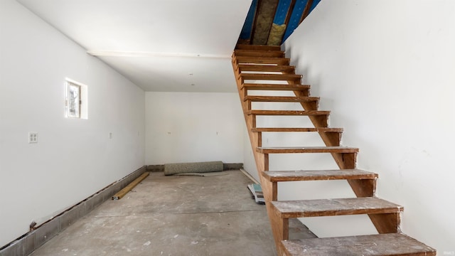 staircase featuring concrete flooring