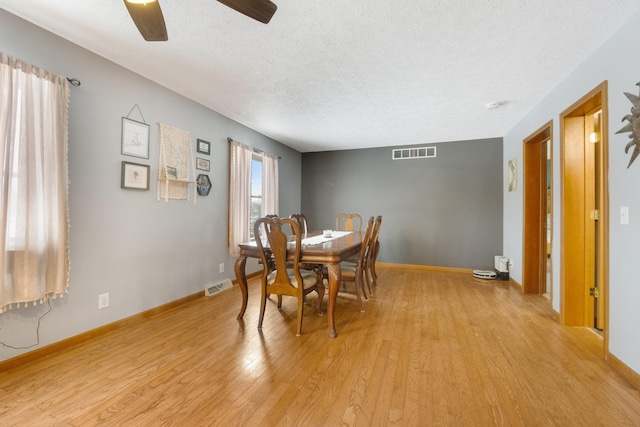 dining room featuring a textured ceiling, ceiling fan, and light hardwood / wood-style flooring