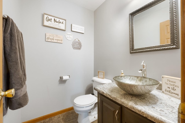 bathroom with toilet, tile patterned flooring, and vanity