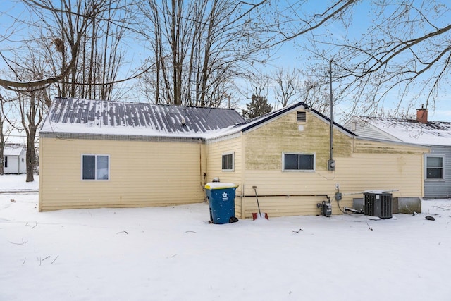 snow covered house featuring central air condition unit