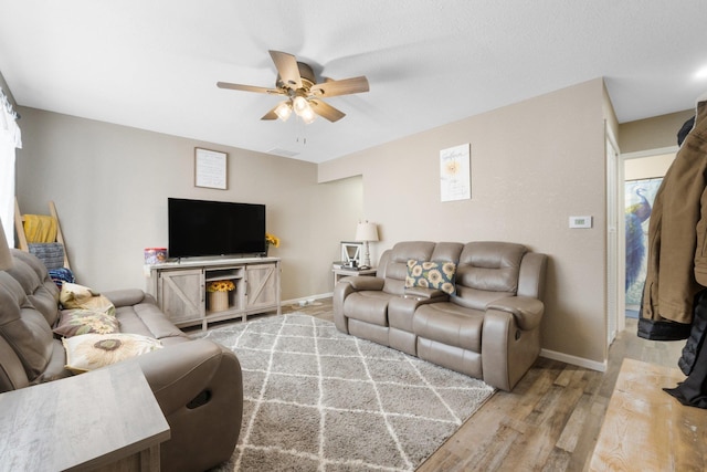 living room featuring ceiling fan and light hardwood / wood-style flooring