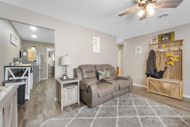 living room featuring light wood-type flooring and ceiling fan