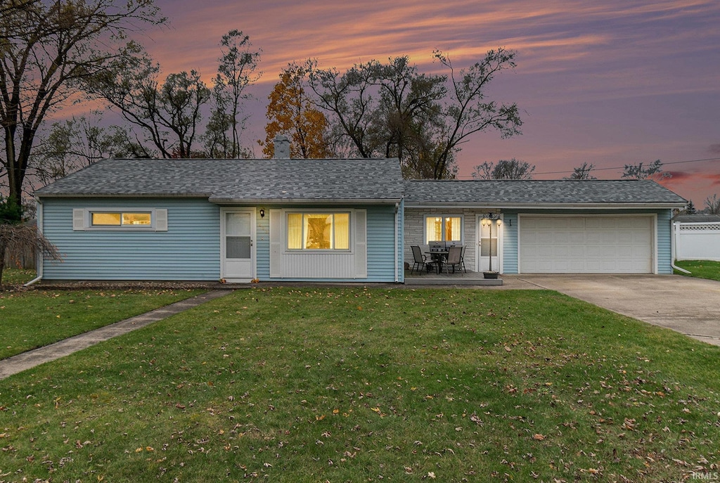 single story home with a yard and a garage