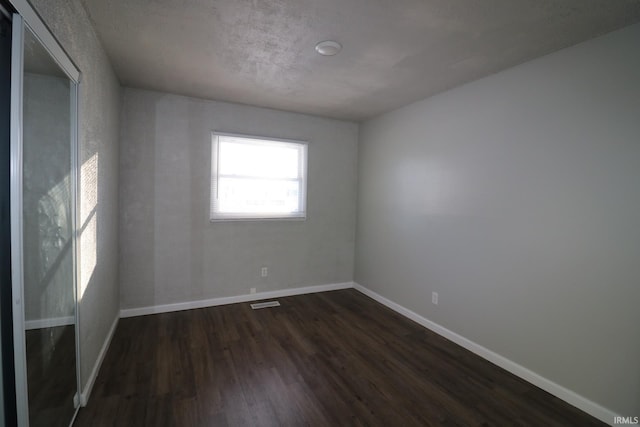 spare room with dark wood-type flooring