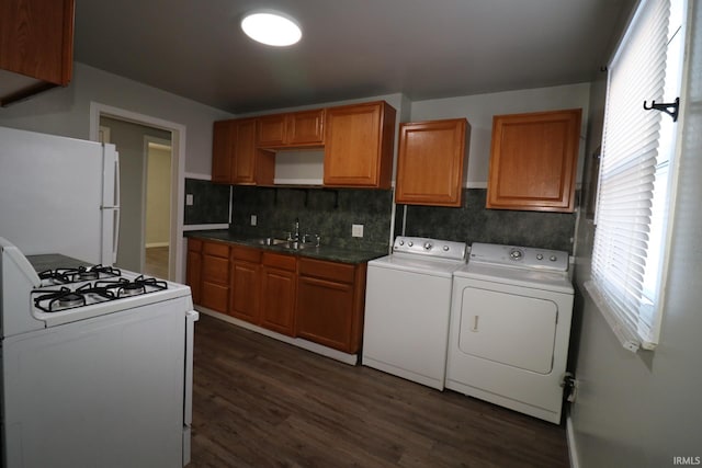 kitchen with white appliances, independent washer and dryer, dark hardwood / wood-style flooring, sink, and tasteful backsplash