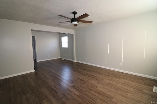 empty room with a textured ceiling, ceiling fan, and dark hardwood / wood-style flooring