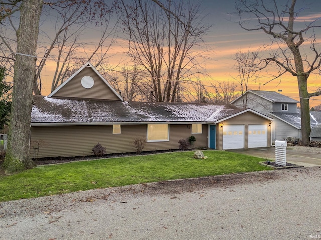 view of front of property with a garage and a lawn