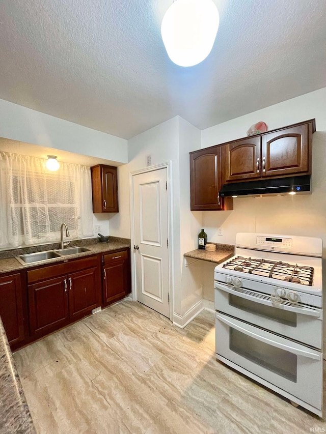 kitchen featuring sink, double oven range, and a textured ceiling