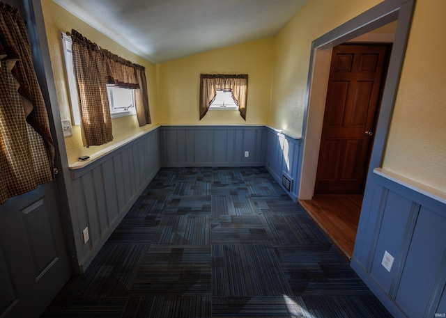 unfurnished room with lofted ceiling