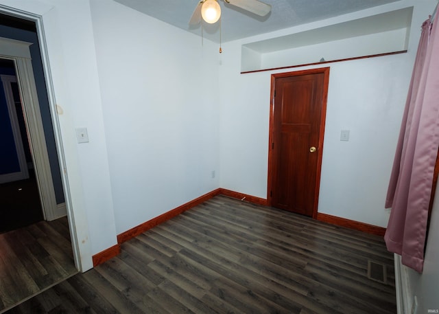 unfurnished bedroom featuring ceiling fan and dark hardwood / wood-style flooring