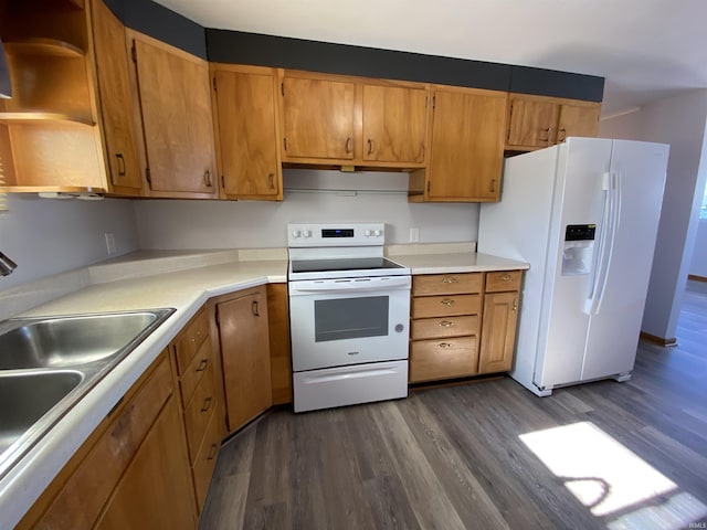 kitchen featuring white appliances, dark wood-type flooring, and sink