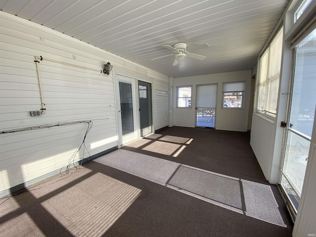 unfurnished sunroom with ceiling fan