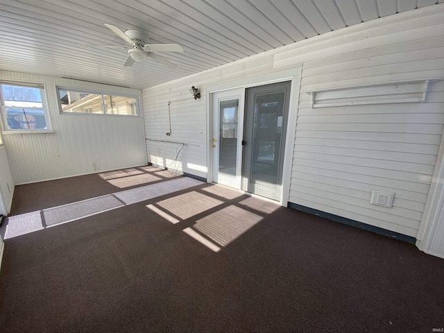 unfurnished sunroom featuring ceiling fan