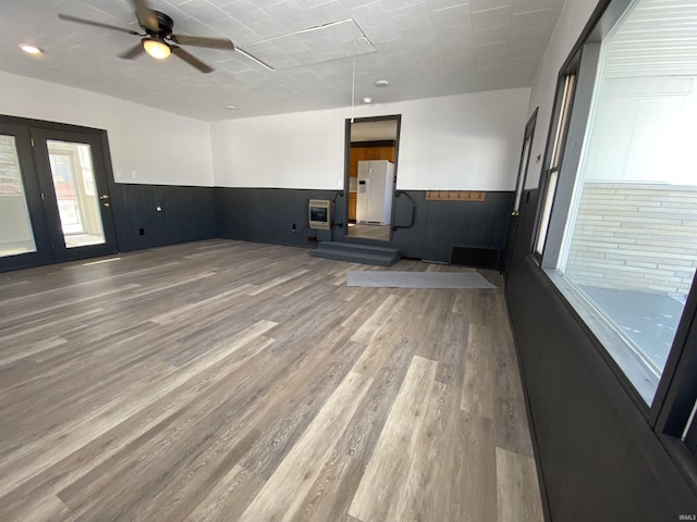 empty room with hardwood / wood-style flooring, ceiling fan, and heating unit