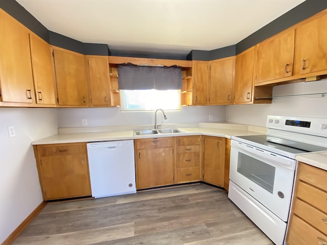 kitchen featuring white appliances, hardwood / wood-style flooring, and sink