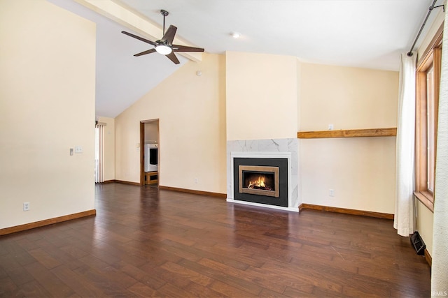 unfurnished living room featuring a high end fireplace, lofted ceiling with beams, dark hardwood / wood-style flooring, and ceiling fan