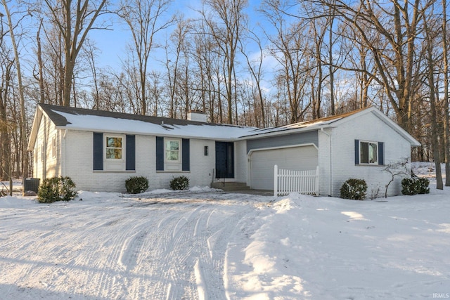 ranch-style home with central AC unit and a garage