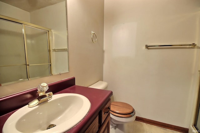 bathroom with vanity, a shower with shower door, and toilet