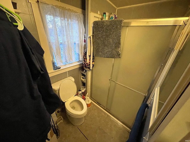 bathroom featuring walk in shower and toilet