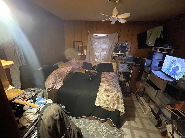 bedroom with wood walls and ceiling fan