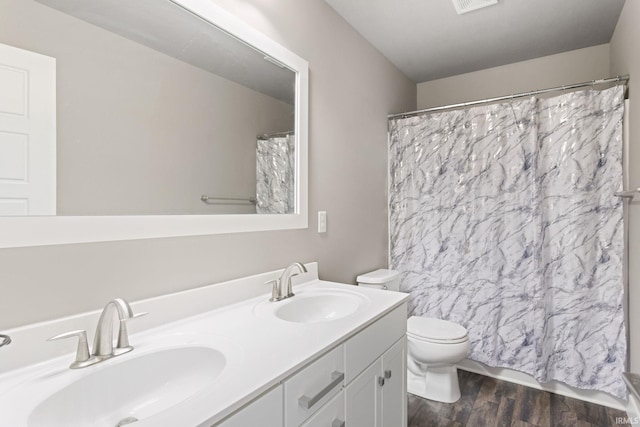 bathroom featuring curtained shower, hardwood / wood-style floors, vanity, and toilet