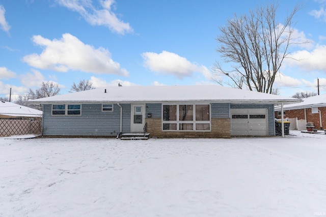 snow covered back of property with a garage