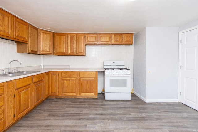 kitchen featuring white gas range, light wood-type flooring, and sink